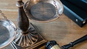 Balanza de la justicia y mazo de juez sobre una mesa de madera